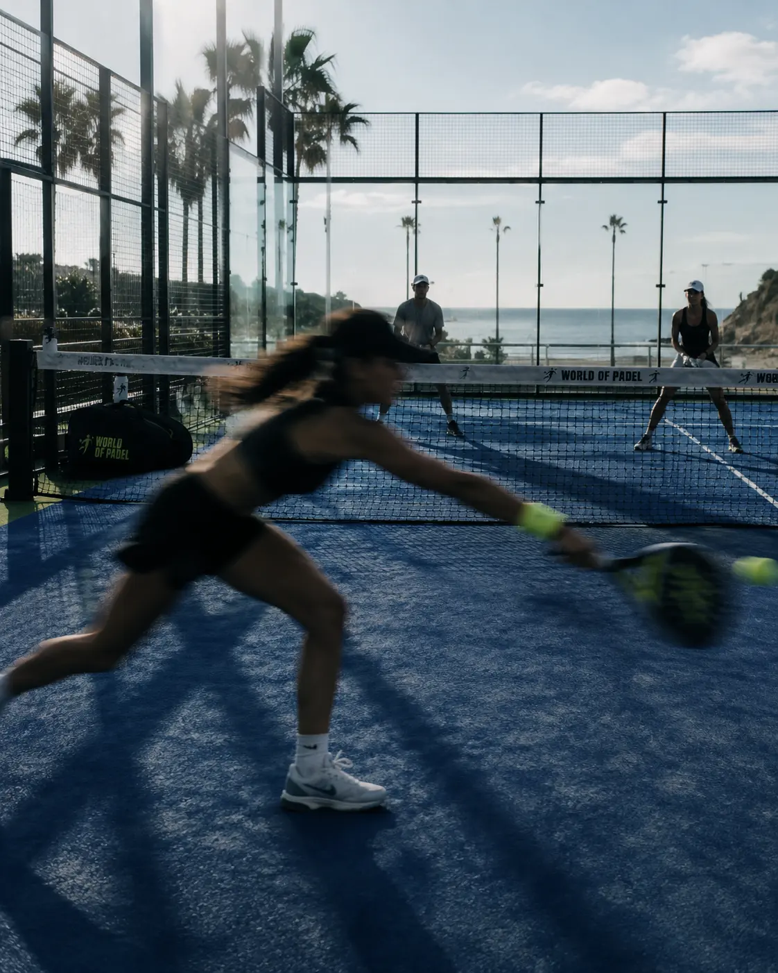 Court No. 03 under the canopy, a player at full stretch with the coast in the background